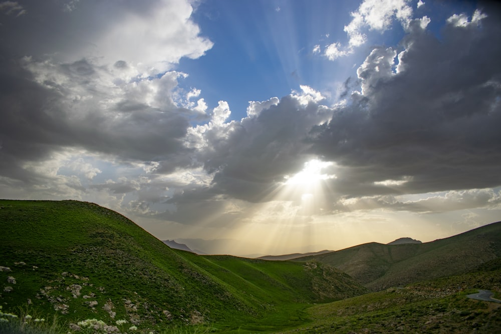 green mountains under blue sky and white clouds during daytime