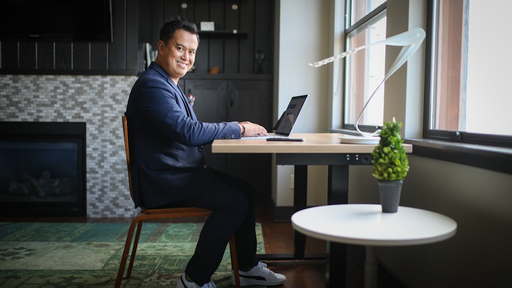 man in black dress shirt and black pants sitting on chair