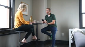 man in green polo shirt sitting beside woman in yellow shirt