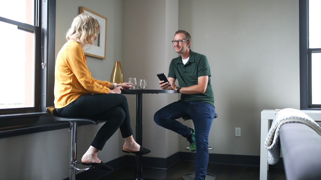 man in green polo shirt sitting beside woman in yellow shirt