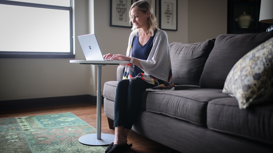 woman in gray long sleeve shirt sitting on black couch
