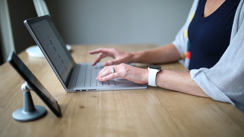 person in white and blue shirt using macbook pro