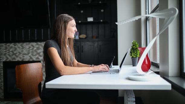 woman in black tank top using macbook pro
