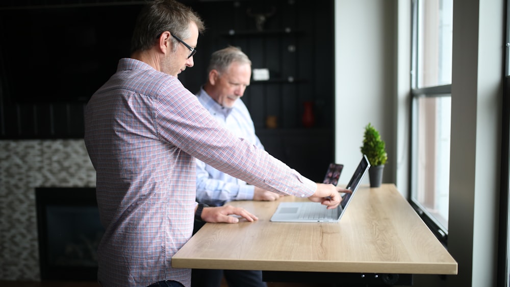 man in purple and white checkered dress shirt using macbook pro