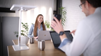 woman in white long sleeve shirt sitting at the table using macbook