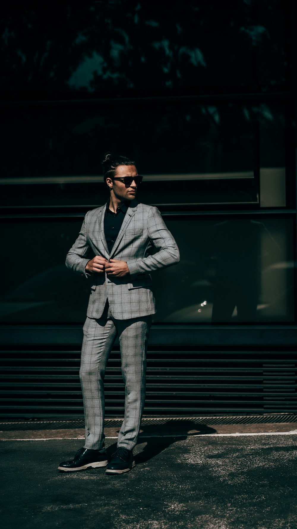 man in black leather jacket and gray pants wearing black sunglasses