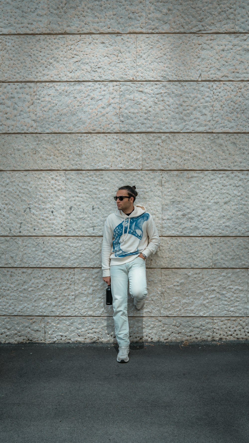 man in white and blue striped long sleeve shirt leaning on wall