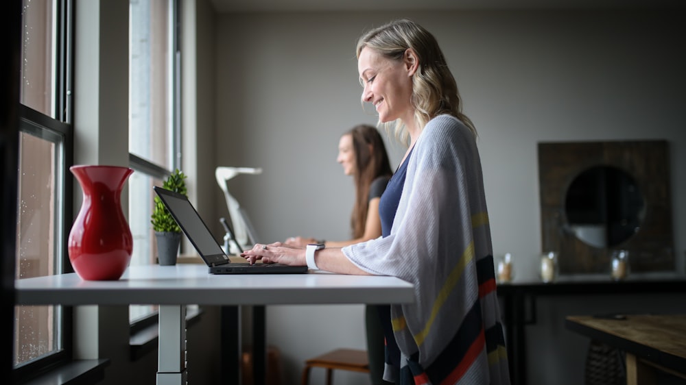 woman in gray tank top using macbook air