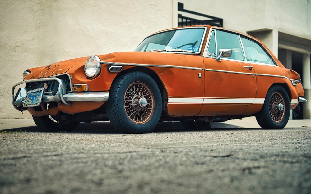 orange and black car on gray asphalt road