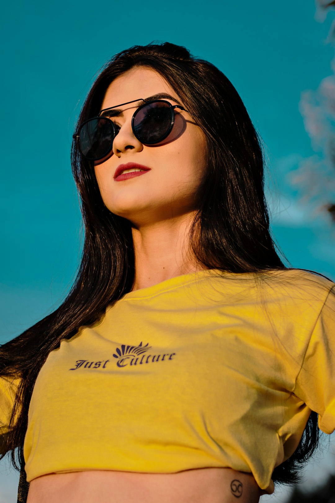 woman in yellow crew neck shirt wearing black sunglasses