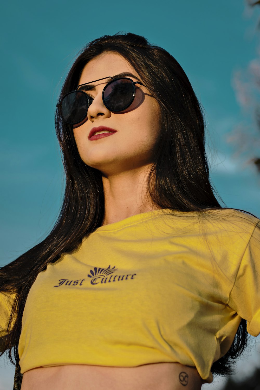 woman in yellow crew neck shirt wearing black sunglasses