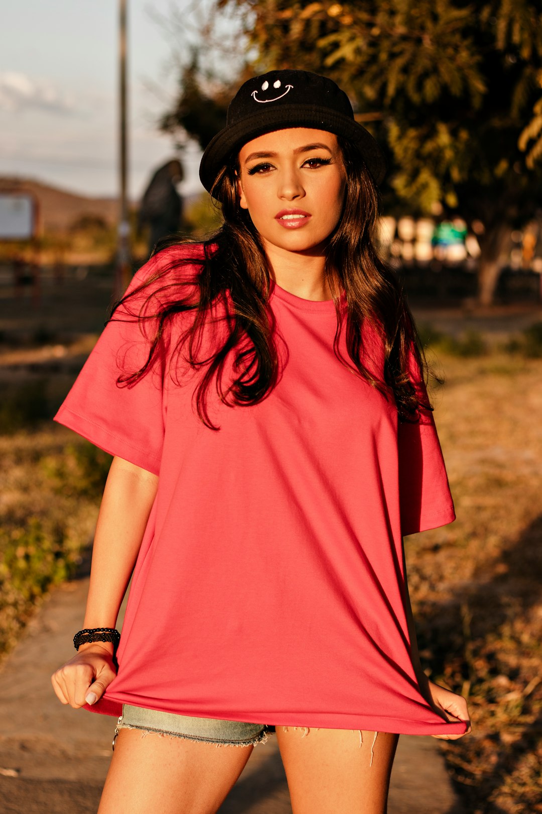 woman in red crew neck t-shirt standing on brown field during daytime