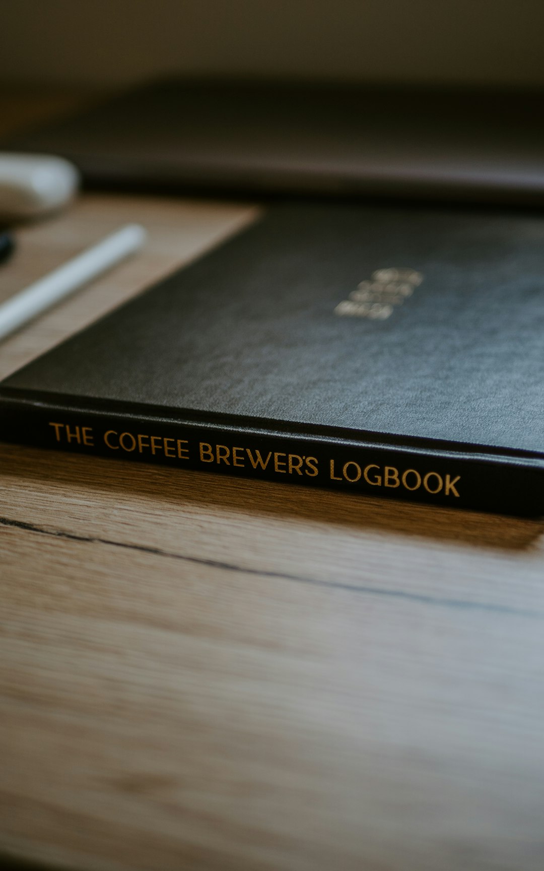 black and gold book on brown wooden table