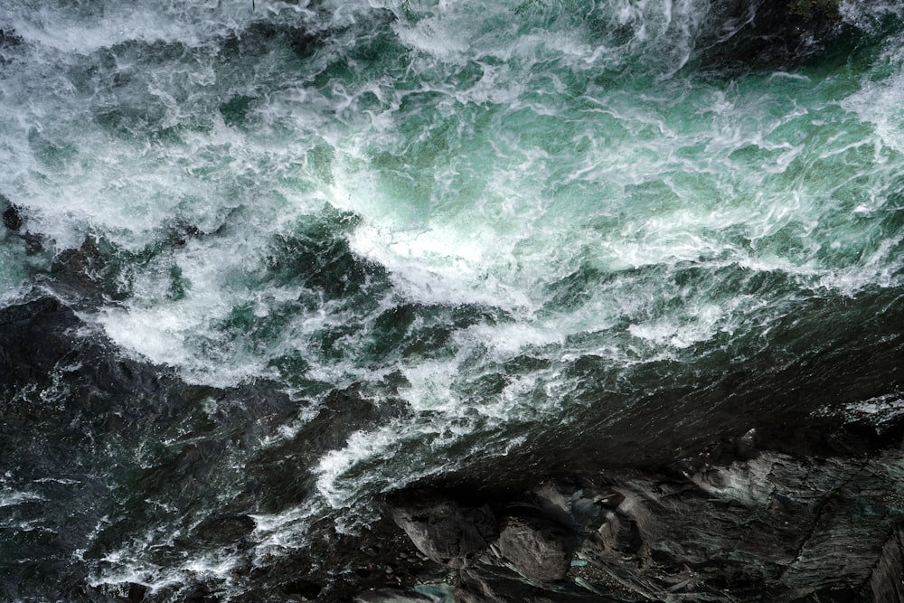 ocean waves crashing on rocky shore during daytime