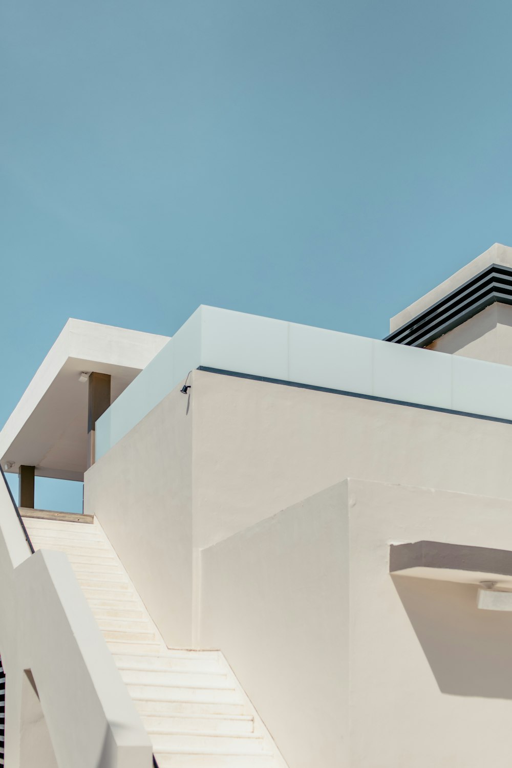 edificio in cemento bianco sotto il cielo blu durante il giorno