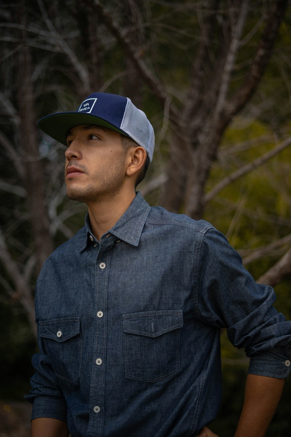 man in blue dress shirt and blue fitted cap