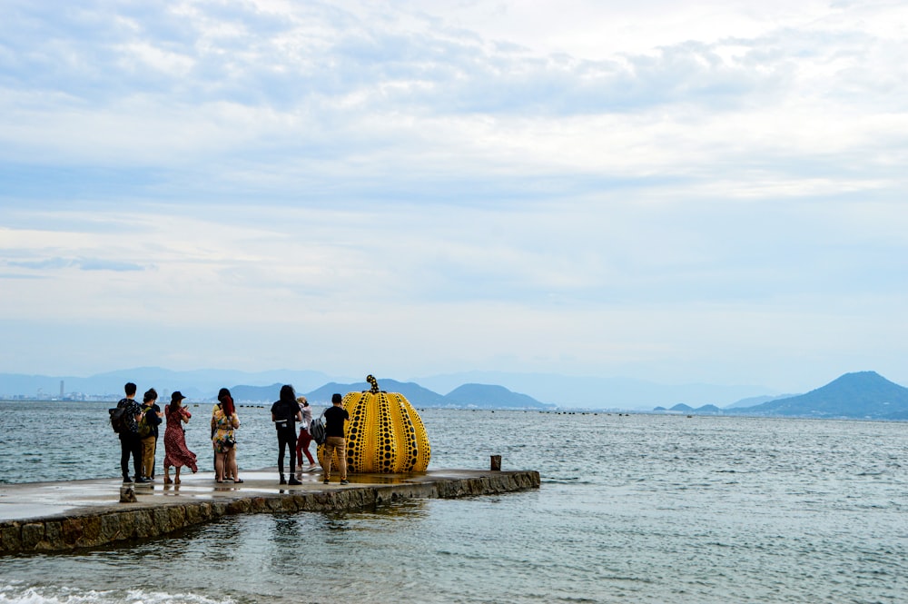 people standing on gray concrete dock during daytime