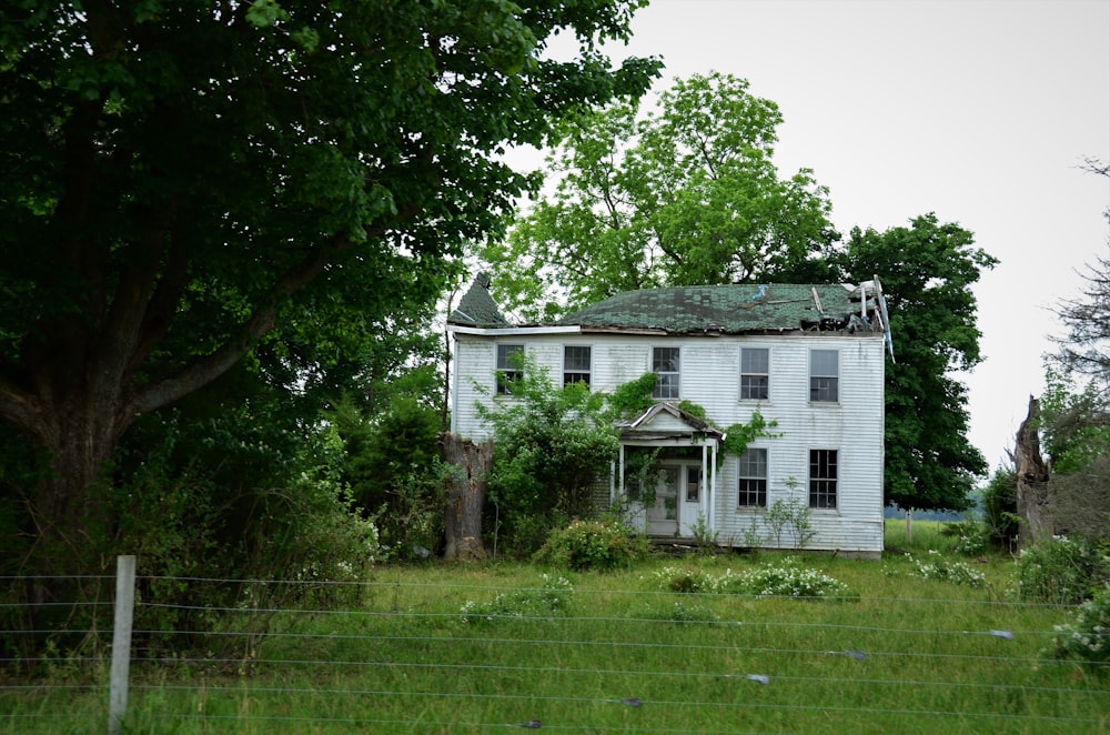 white and gray concrete house near green trees during daytime