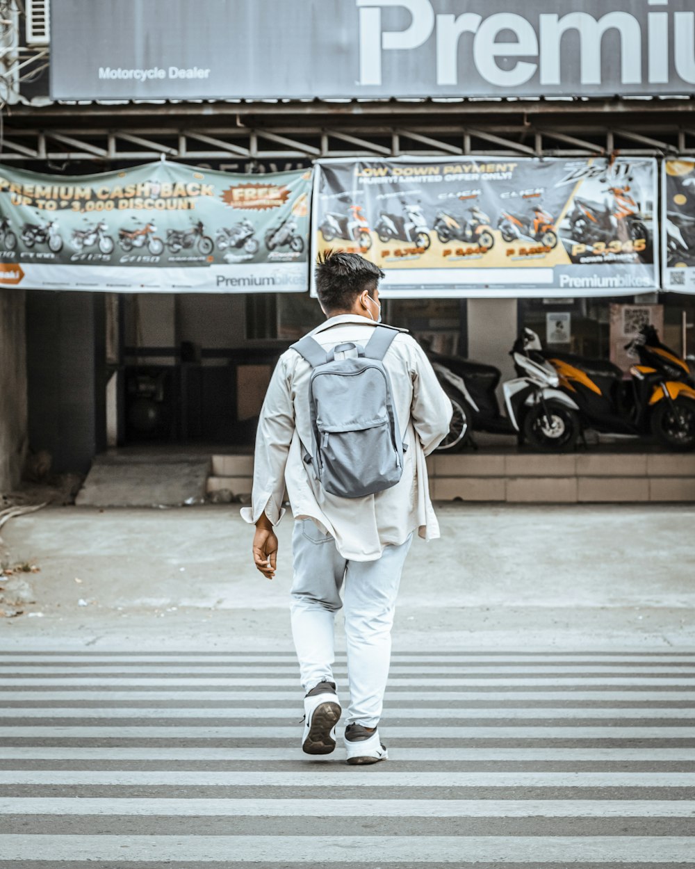 man in white jacket walking on pedestrian lane during daytime