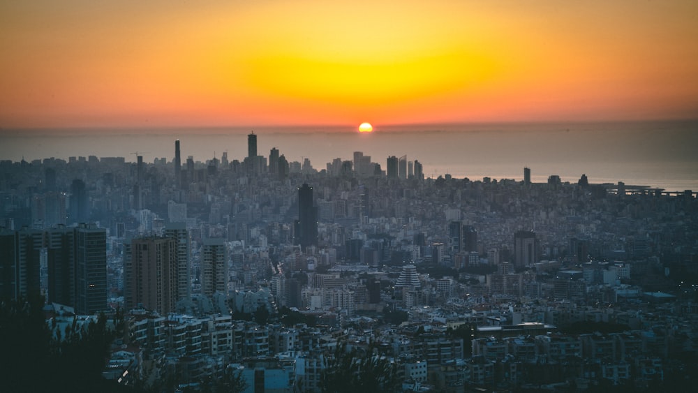 horizonte da cidade durante o pôr do sol com céu alaranjado