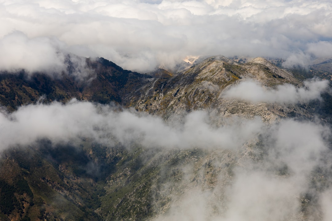 brown and green mountain under white clouds during daytime