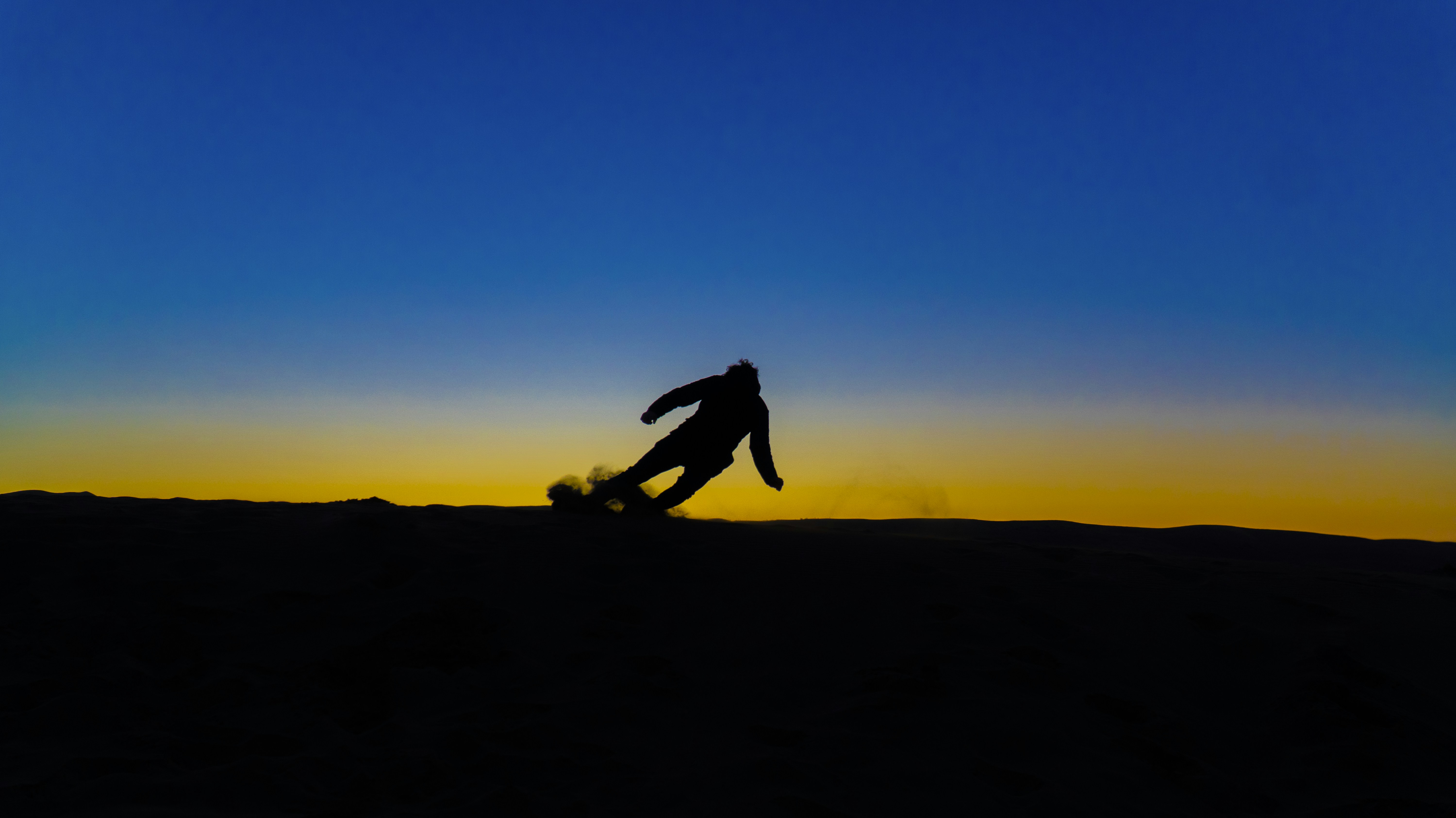 silhouette of 2 person jumping on hill during sunset