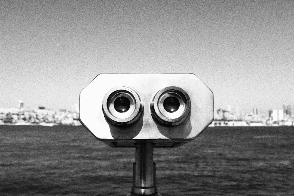 grayscale photo of binoculars on the ground