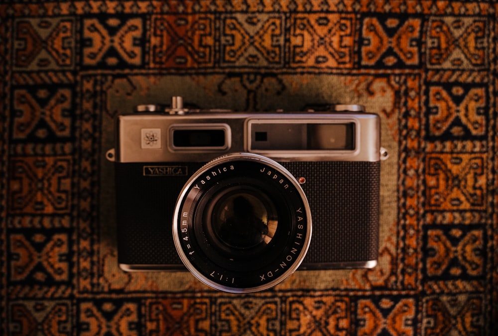 black and silver camera on brown and black textile