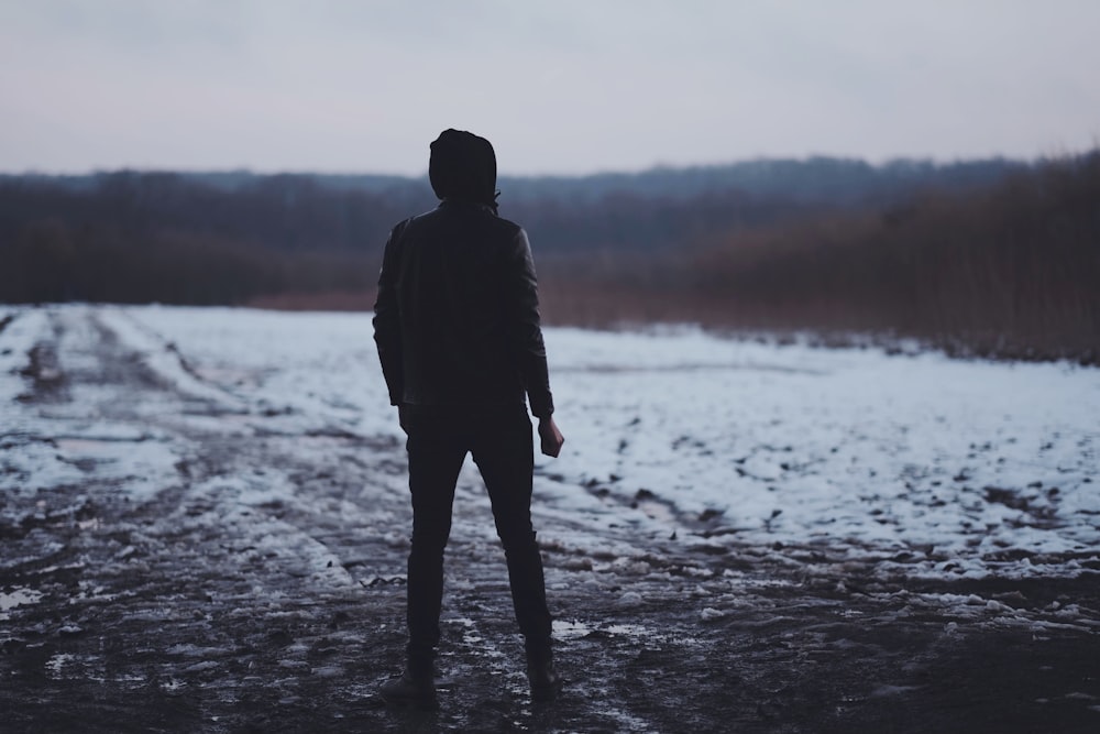 man in black jacket standing on the shore during daytime