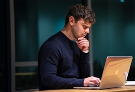 man in black long sleeve shirt sitting in front of macbook