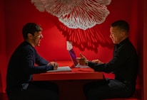 An author and consultant engaged in a lively discussion over manuscripts and notes.