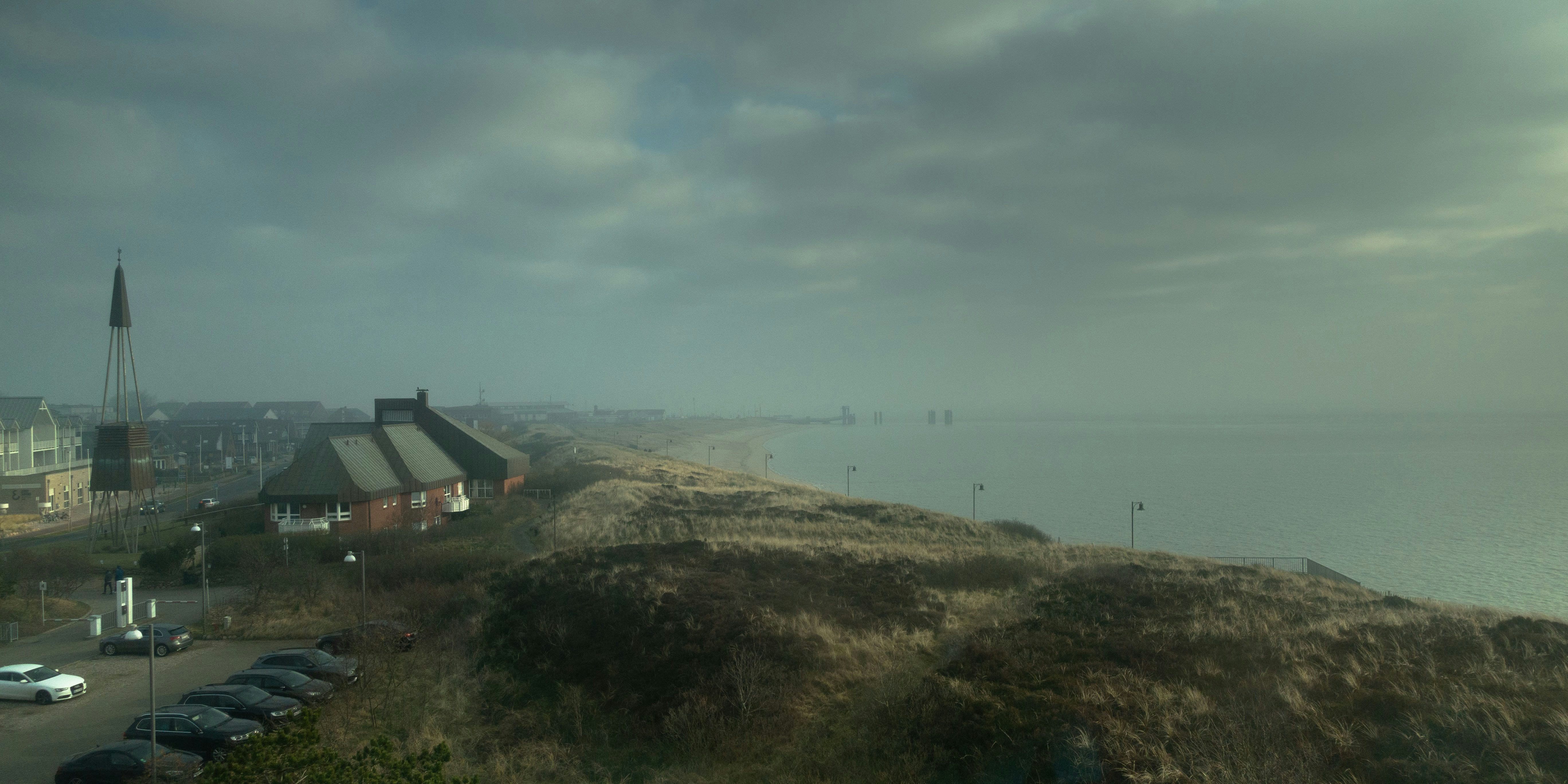 white and black house on green grass field under gray sky