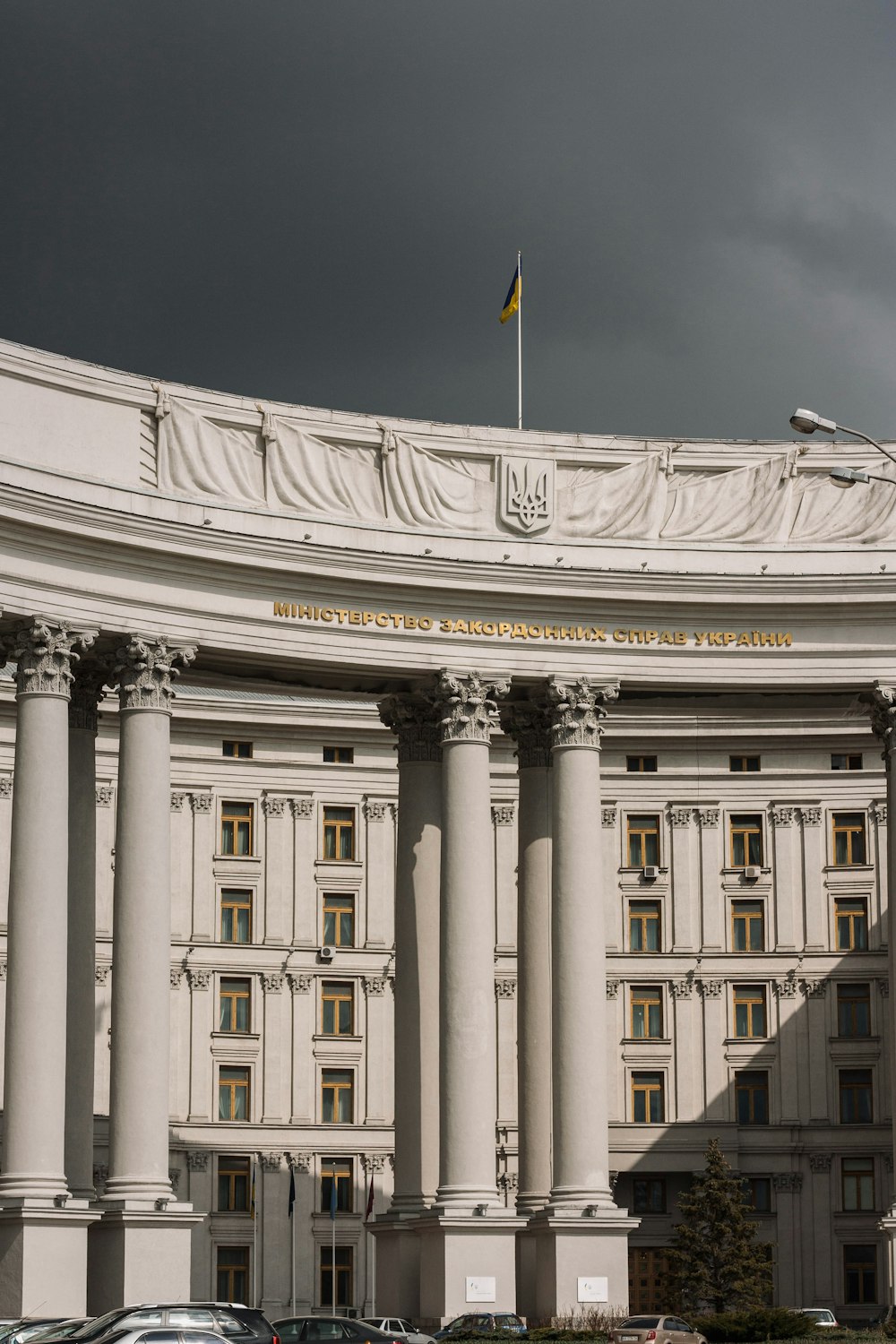 white concrete building with flag on top under blue sky during daytime