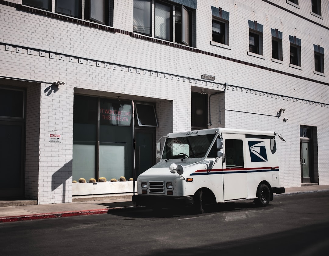 white van parked in front of white concrete building during daytime