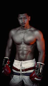 A fighter mid-punch, muscles tense, framed by deep jungle shadows and warm golden light.