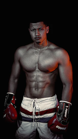 Portrait of Stefano Paternò in MMA gear, focused and determined in a dark training environment.