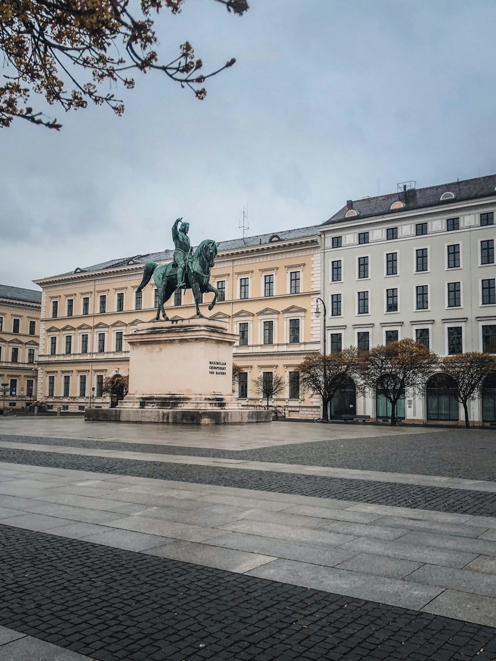 white concrete building with statue of man riding horse statue