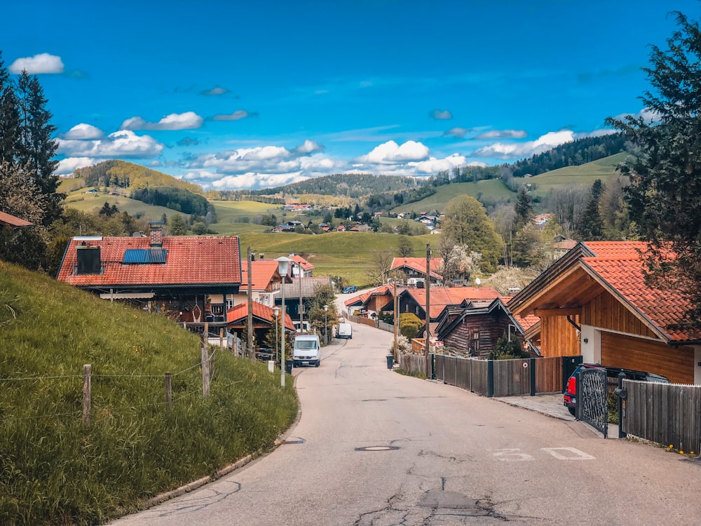 brown wooden houses near green grass field during daytime