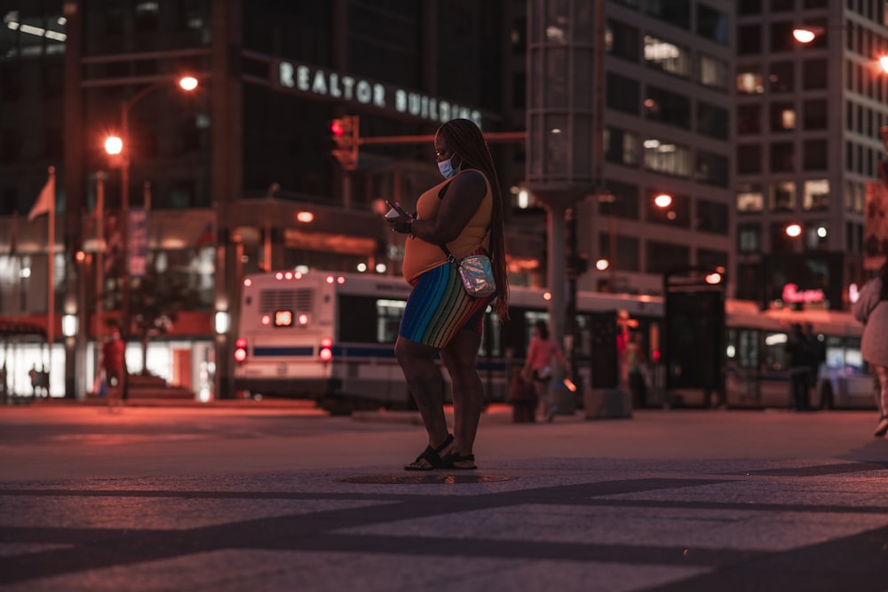 woman in red and white dress walking on street during night time