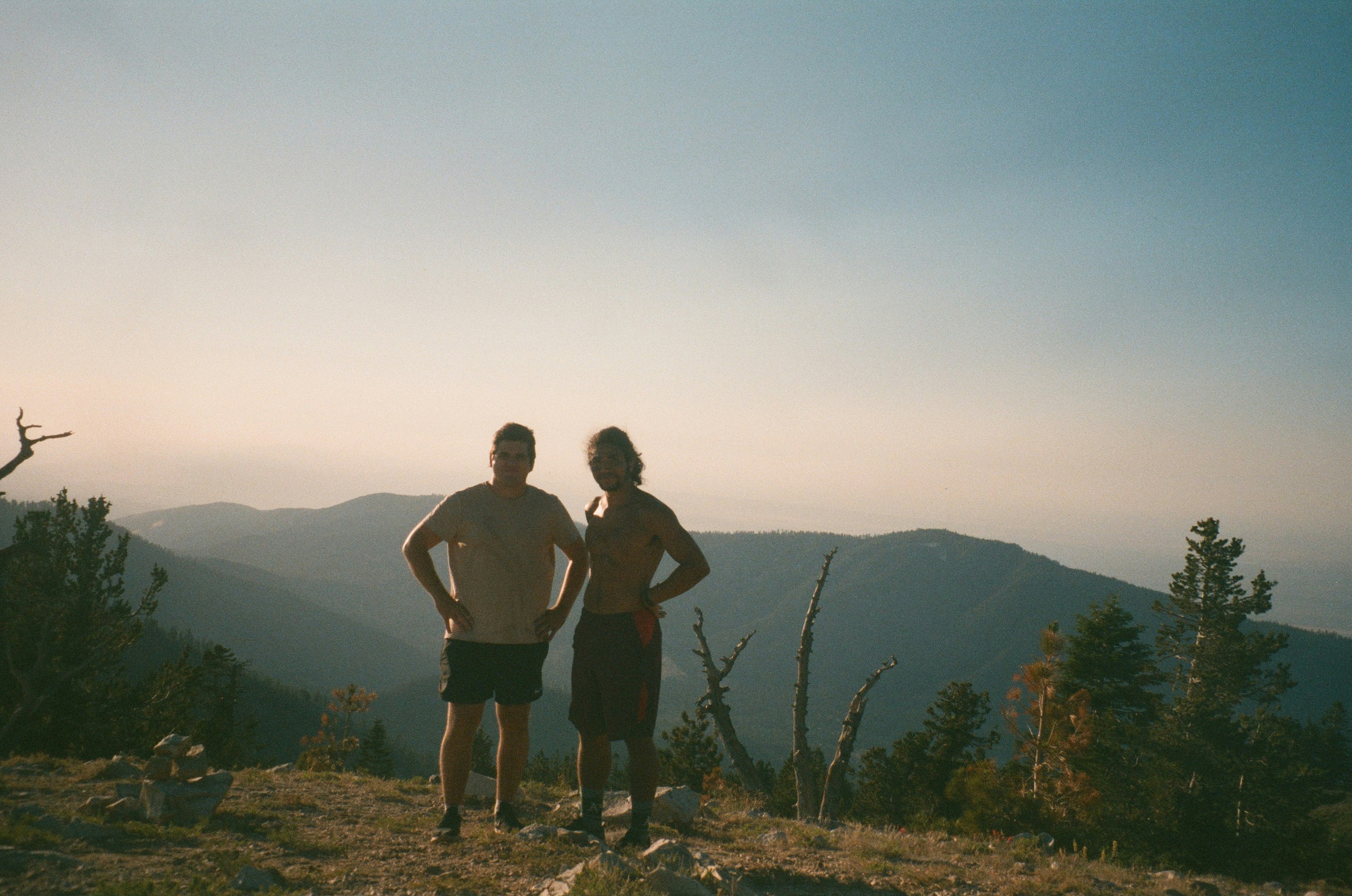 2 men standing on mountain during daytime