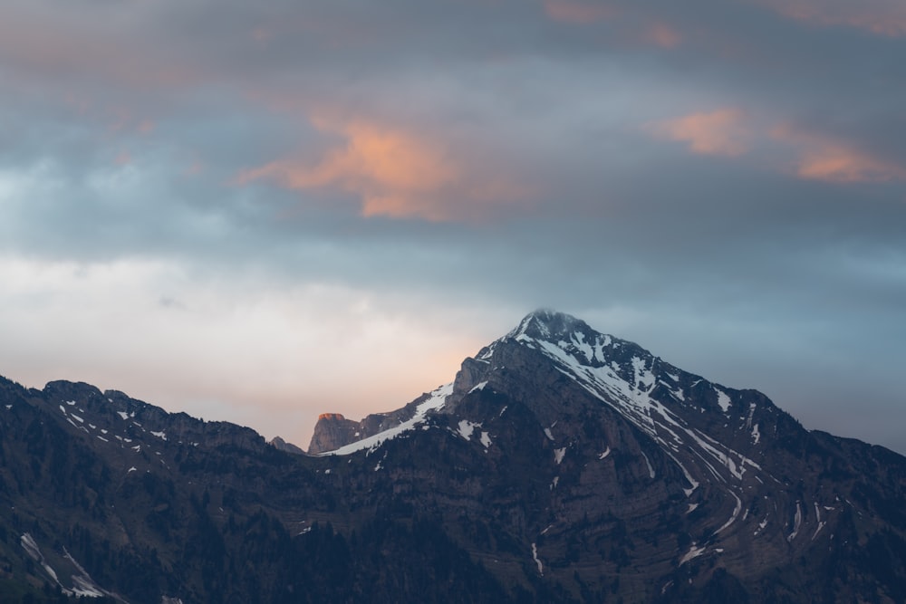 snow covered mountain under cloudy sky during daytime