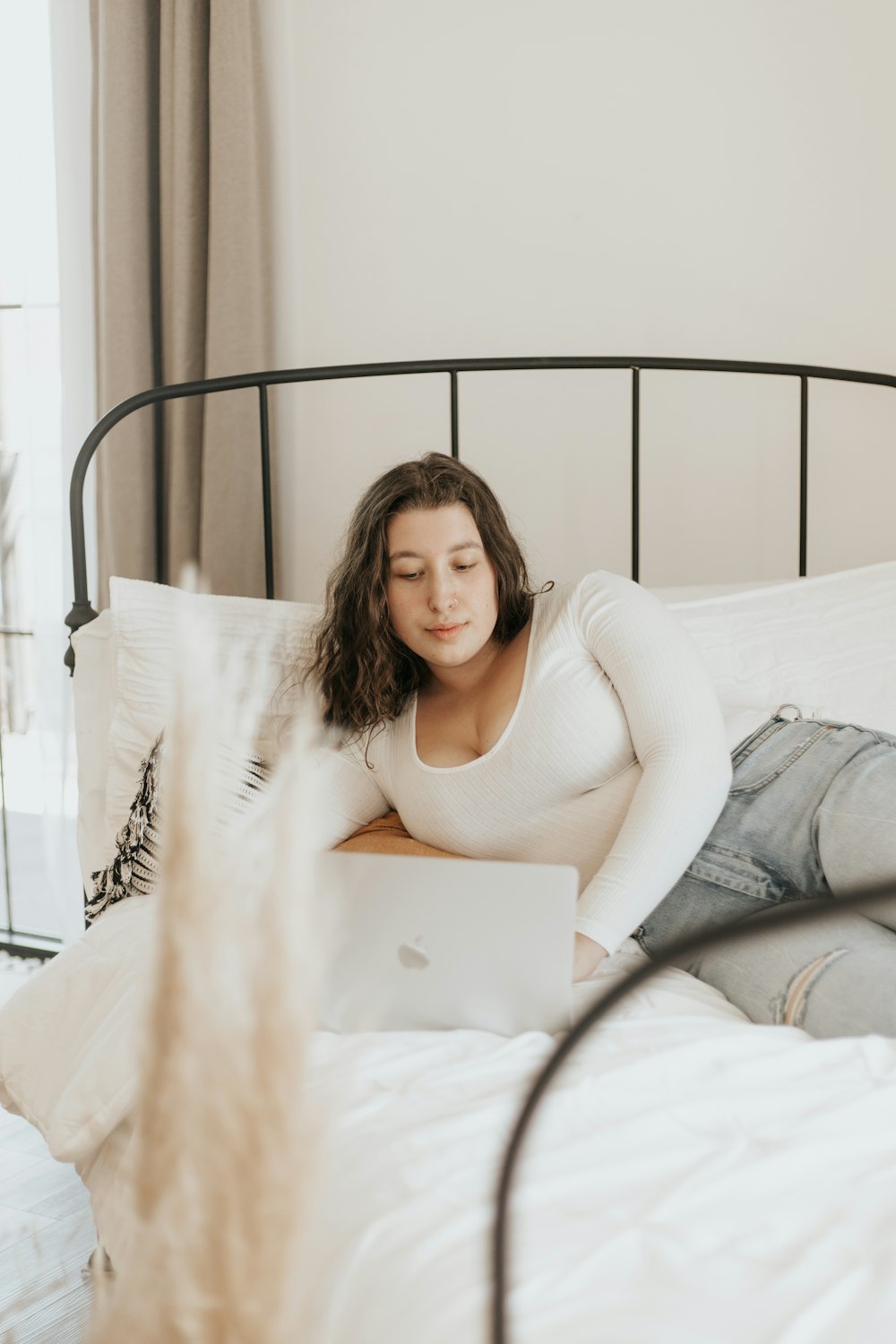 woman in white tank top lying on bed