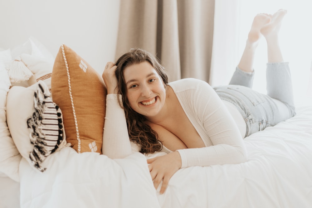woman in white long sleeve shirt lying on bed