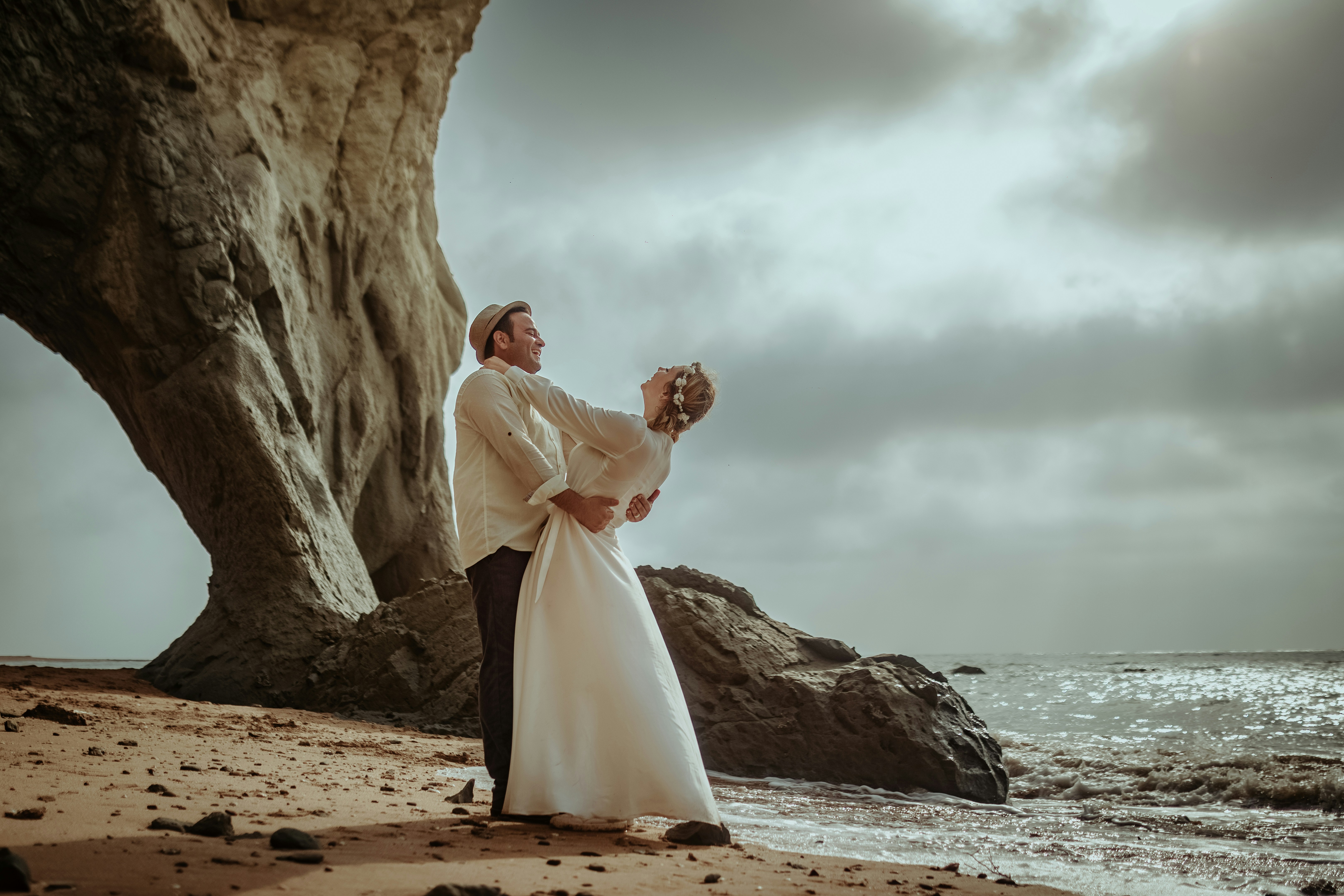 man and woman kissing on beach during daytime