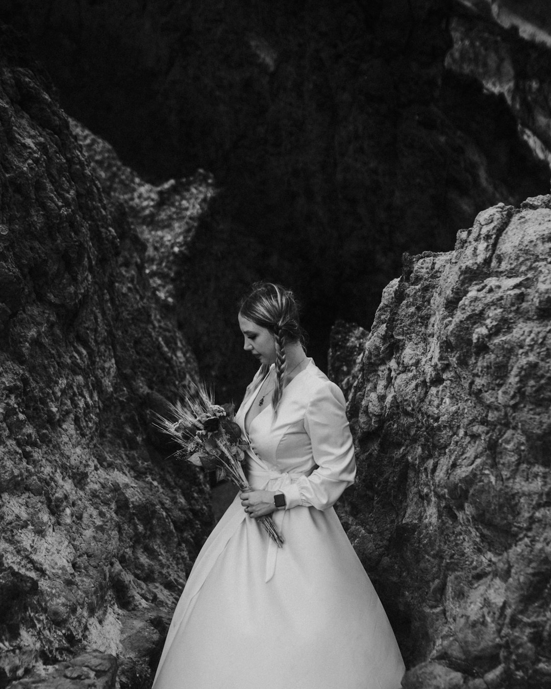 woman in white dress standing near rock formation
