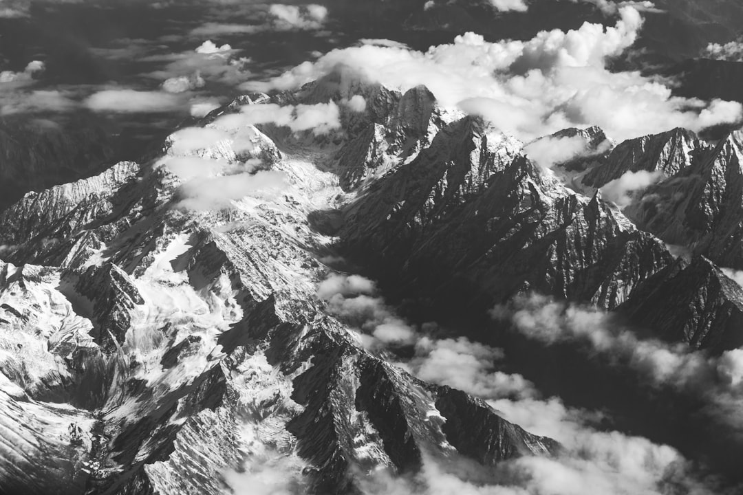 grayscale photo of mountain covered with clouds