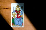 An elegant tarot card illustration of The Empress seated amidst blooming nature.