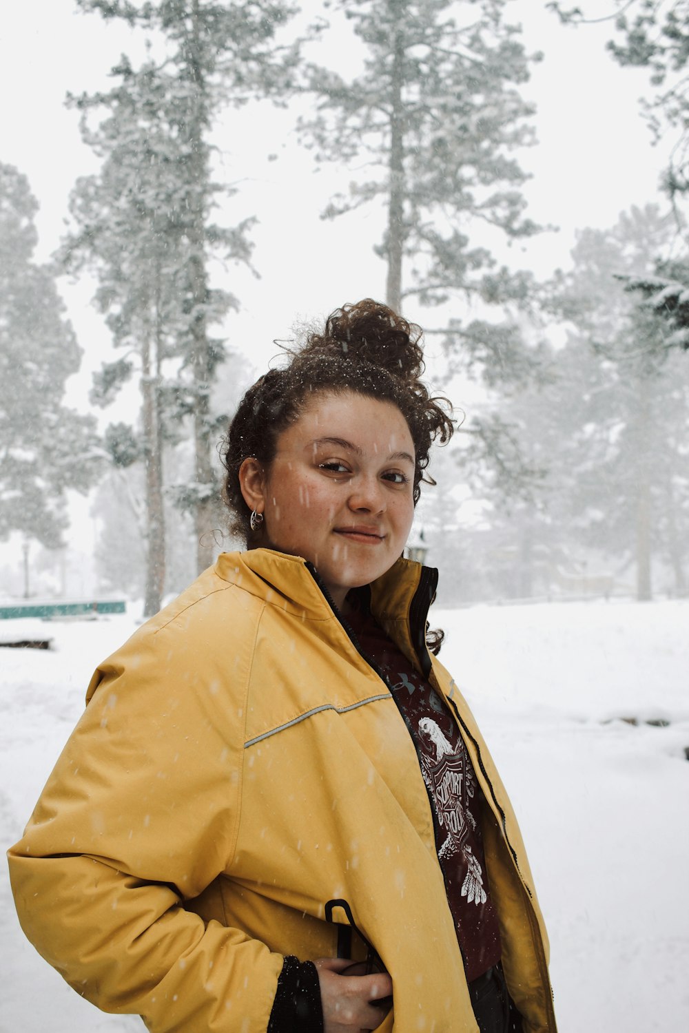 woman in yellow jacket standing on snow covered ground during daytime