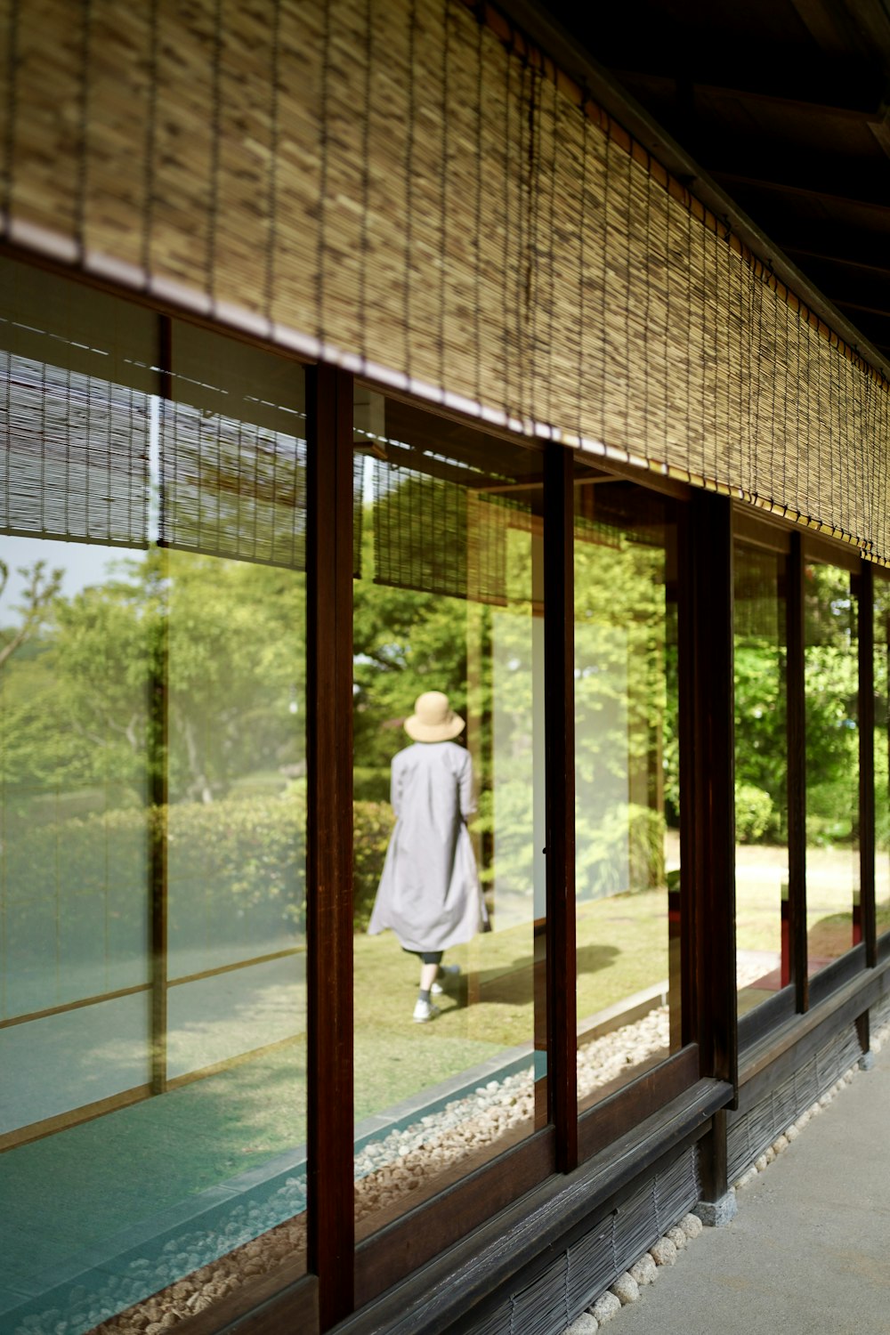 woman in white dress standing near glass window