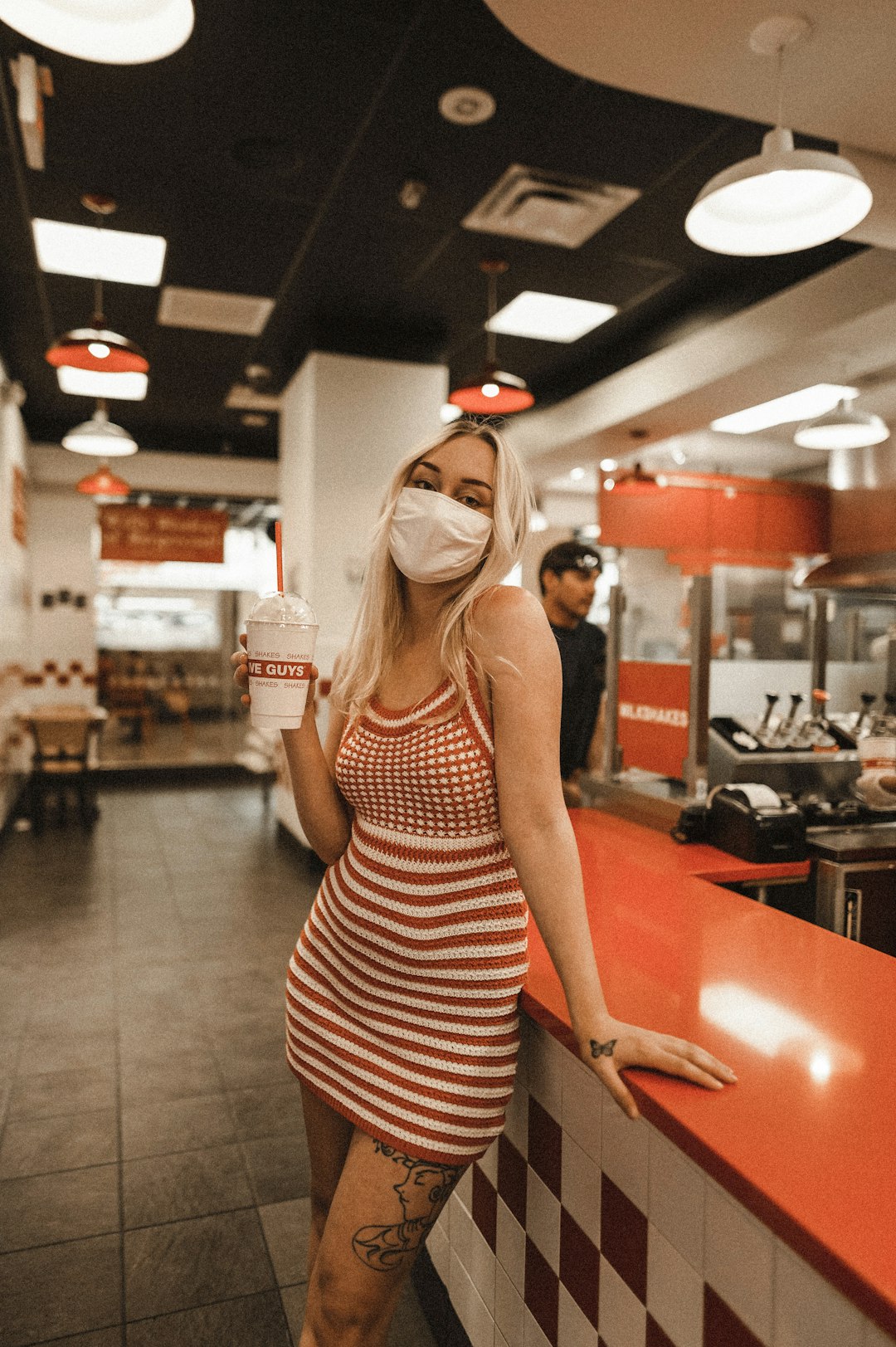 woman in black and white stripe tank top standing near red table